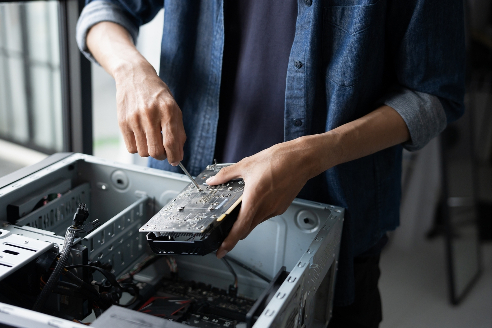 A technician in the process of disassembling a desktop computer